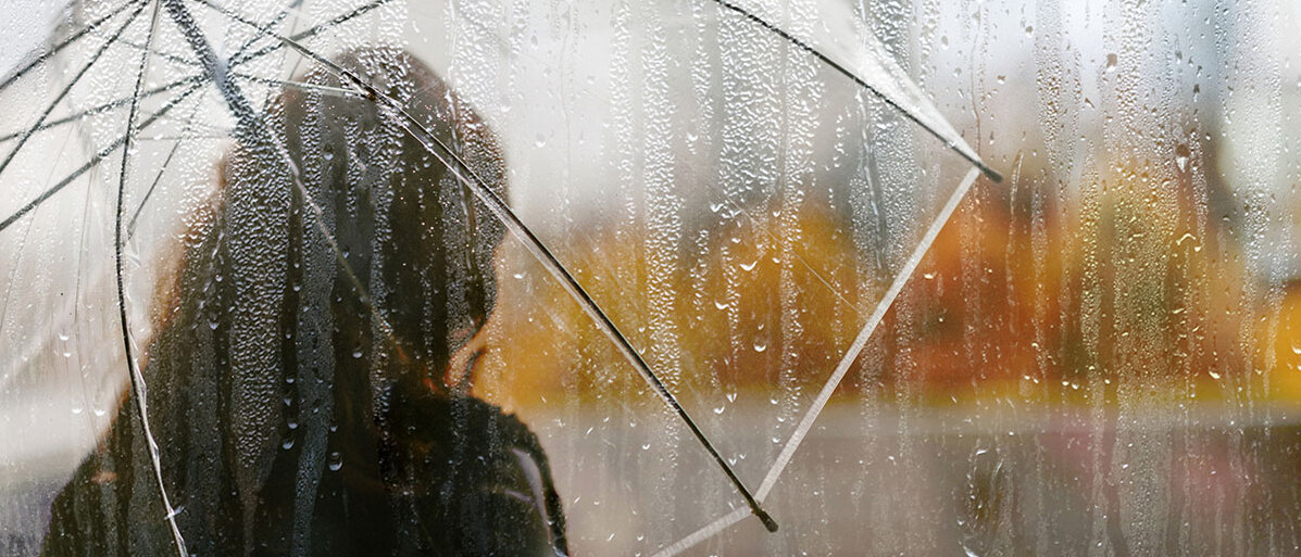 Diabetes und Depression Frau mit durchsichtigem Regenschirm im Herbst