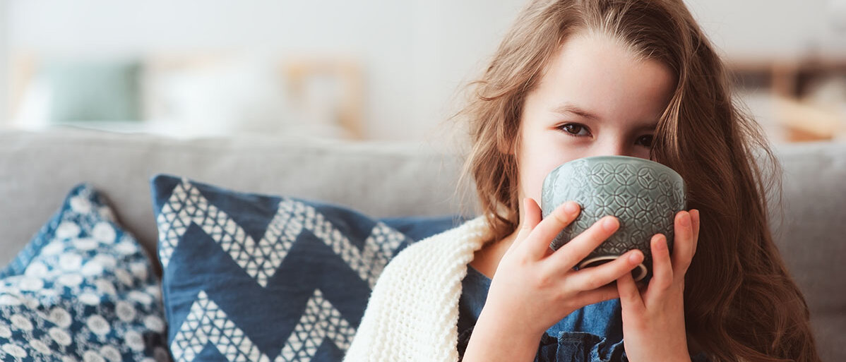 Mädchen trinkt Tee aus Tasse