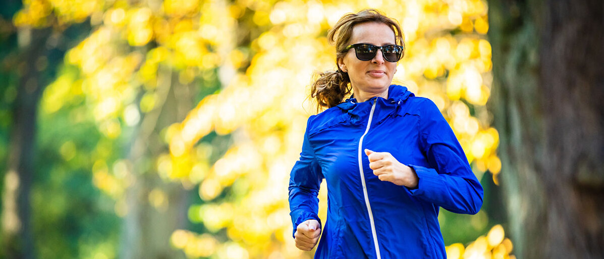 So können Frauen gezielt ihre Herzgesundheit verbessern Frau mittleren Alters mit Sonnenbrille läuft im Park