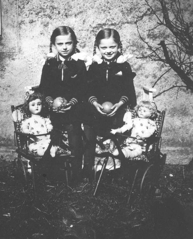 Zwei Schwestern mit zwei Puppen.