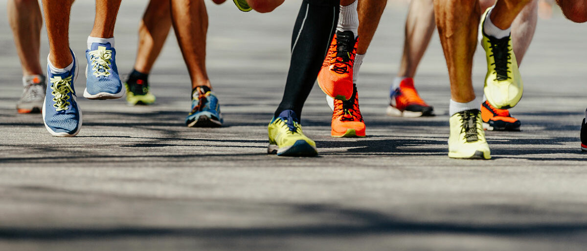Ausschnitt mehrerer rennender Beine in einem Wettlauf