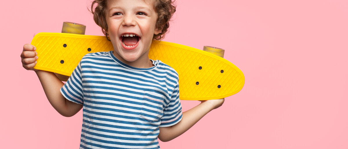 Junge mit Skateboard lacht