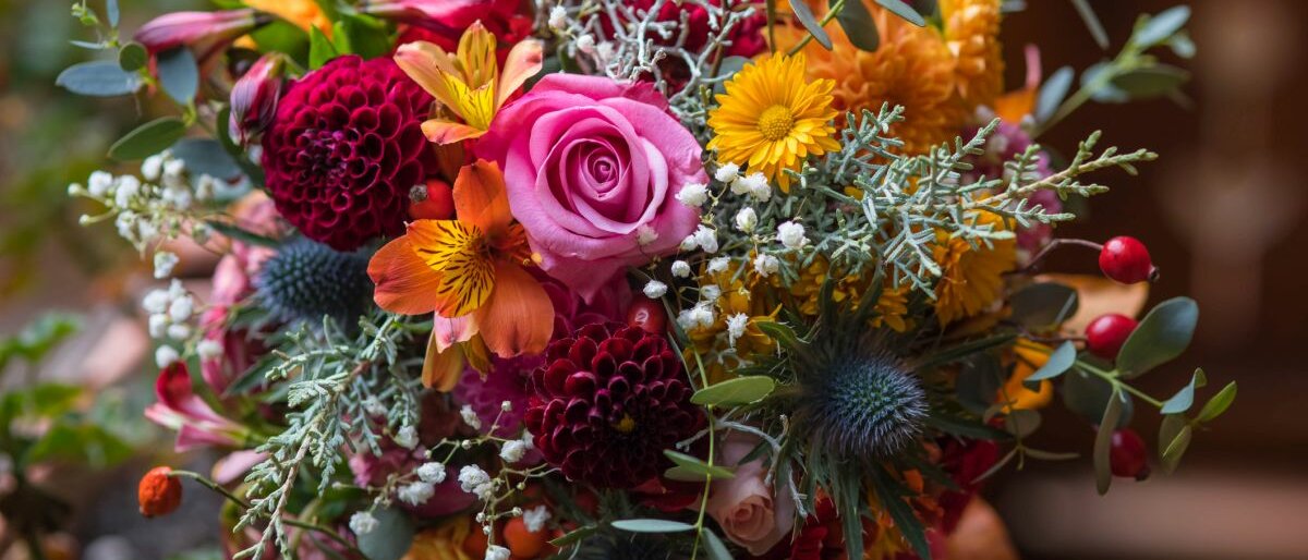 Ein bunter Blumenstrauß mit vielen verschiedenen Blumen in Rosa-, Pink- und Orangetönen.
