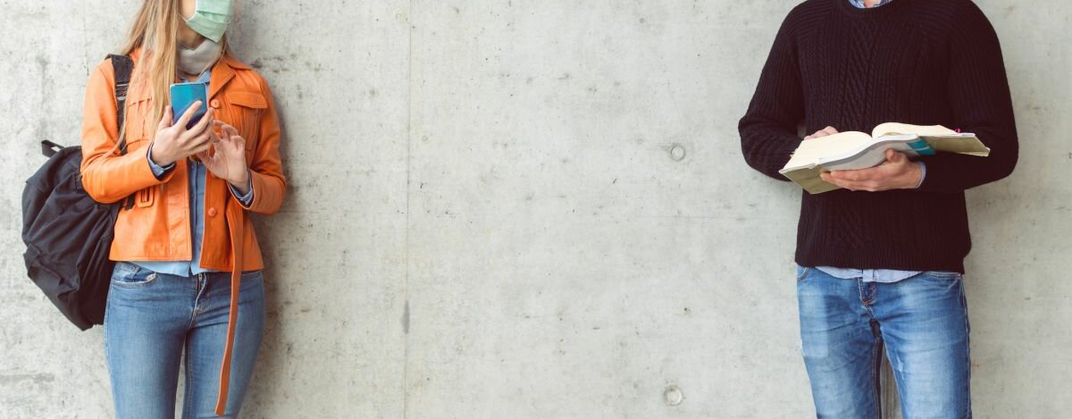 Sicherheitsabstand Eine Frau und ein Mann unterhalten sich. Dabei halten sie den Sicherheitsabstand ein und tragen eine Maske.