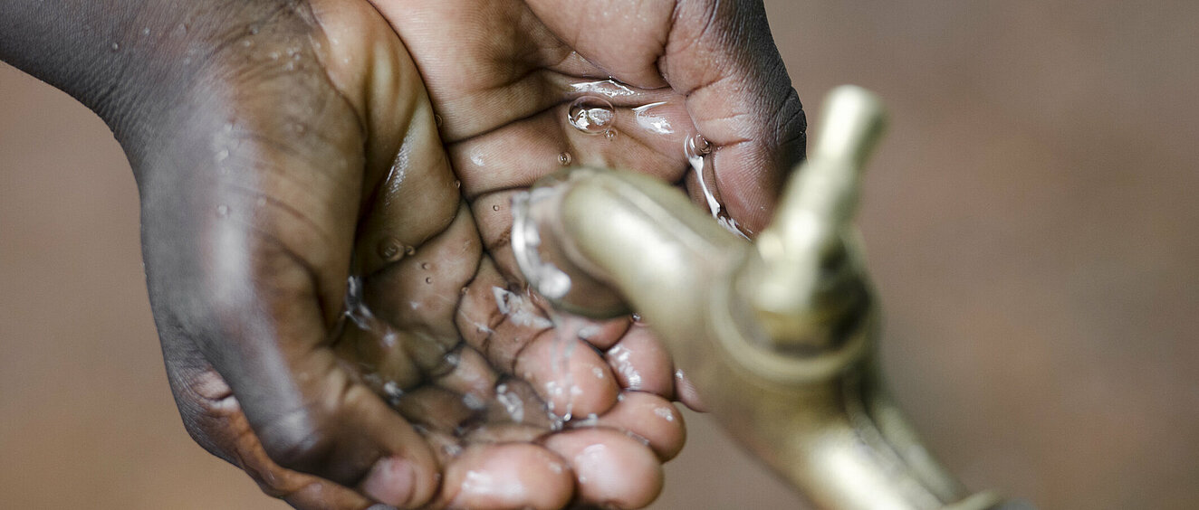 Kind wäscht Hände in Afrika