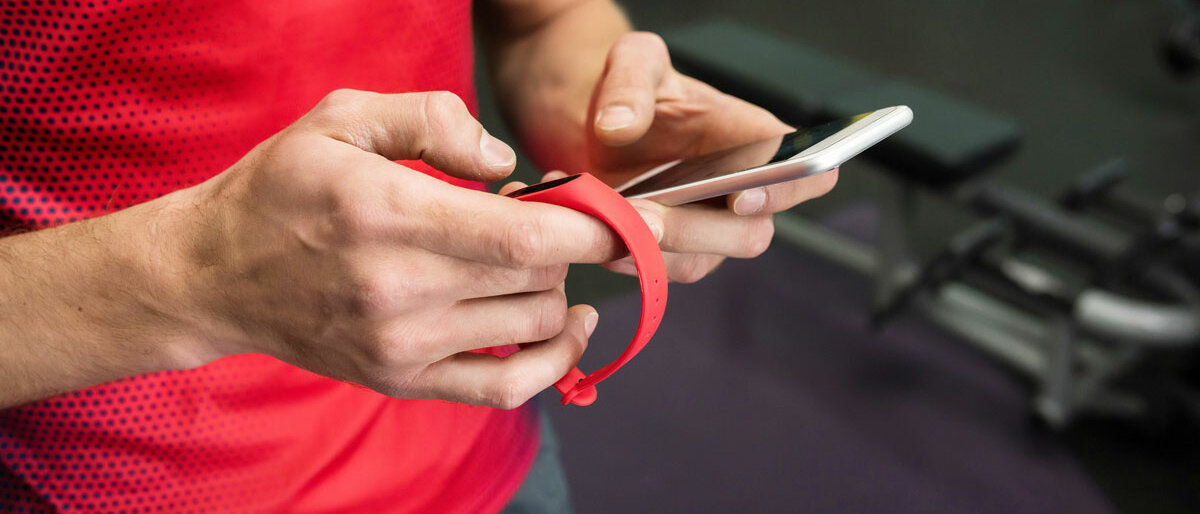 Eine Person checkt sein Fitness-Armband und die dazugehörige App