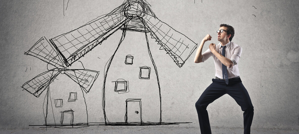 Ein Mann im Anzug steht in Boxhaltung skizzierten Windmühlen gegenüber