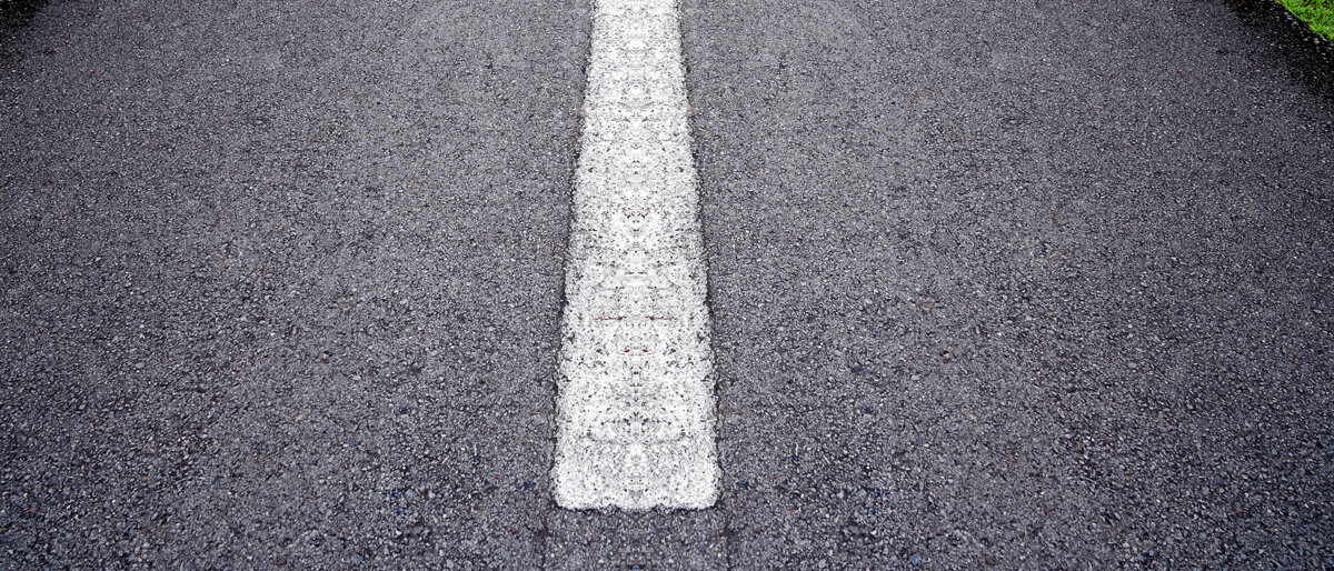 Eine Straße mit einem weißen Richtungspfeil
