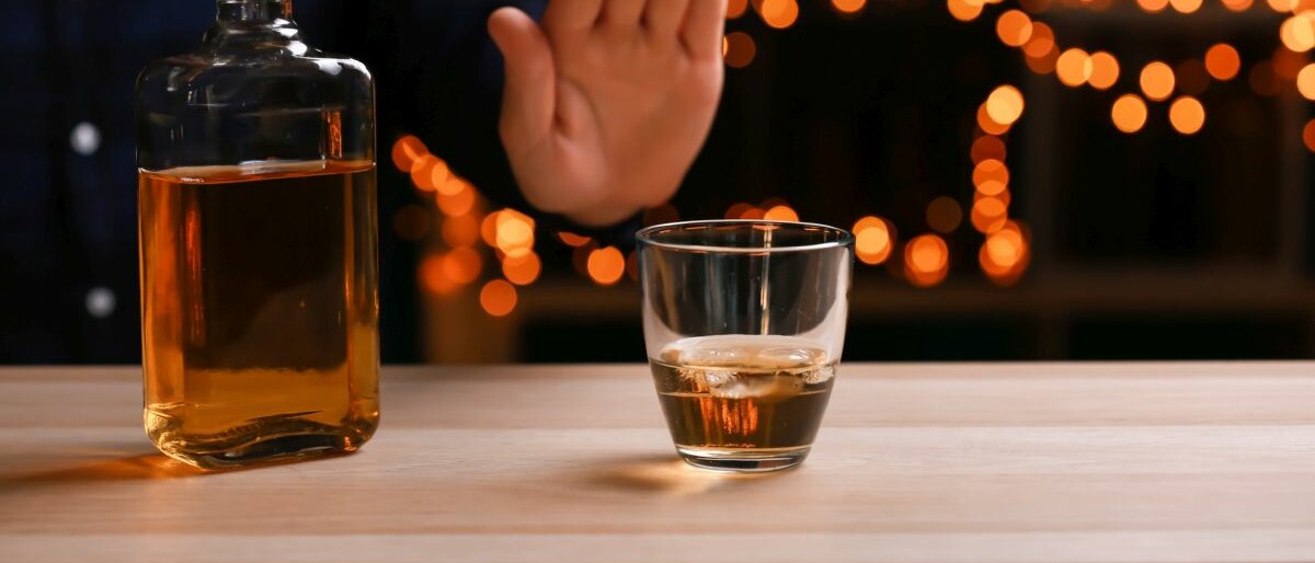 Ein Mann verweigert ein Glas mit alkoholischem Inhalt.