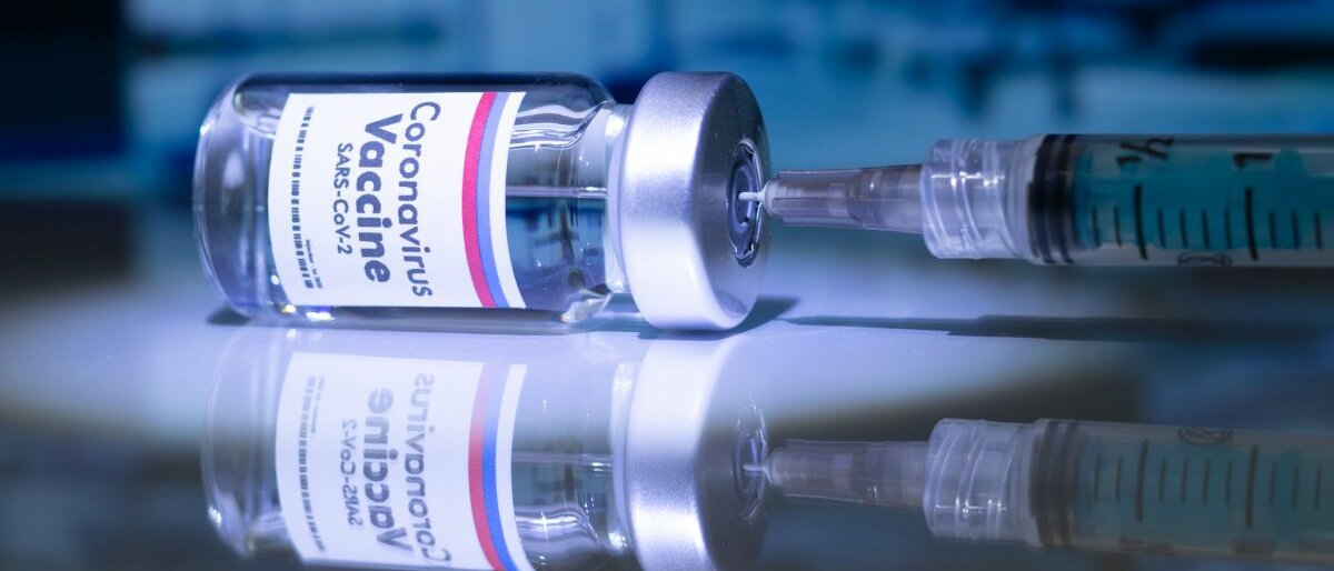 Ein umgekipptes Fläschchen des russischen Corona-Impfstoffs.