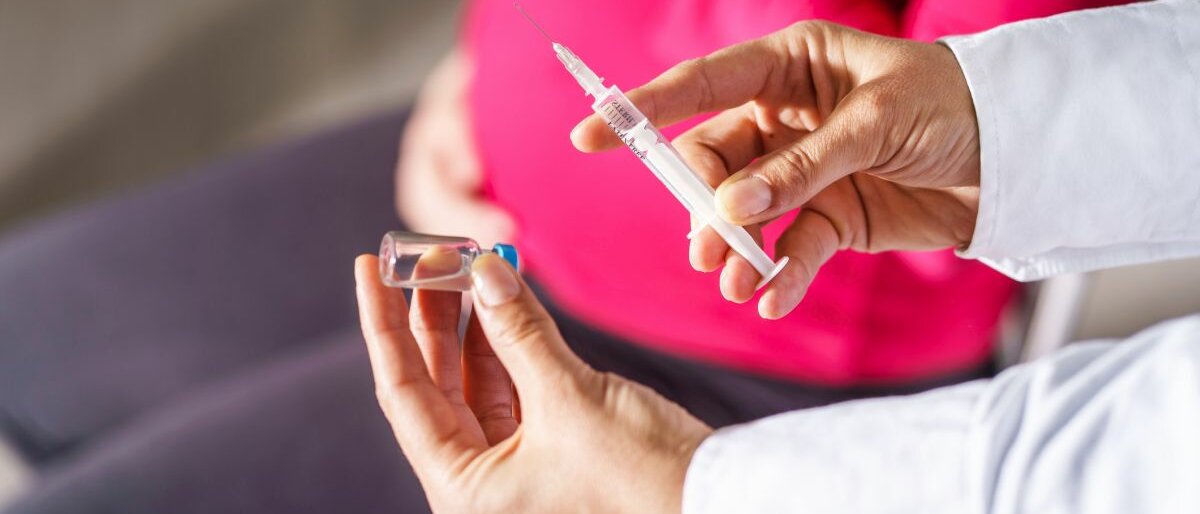 Eine schwangere Frau wird geimpft.