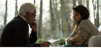 Psychotherapeut mit Patientin vor Waldtapete