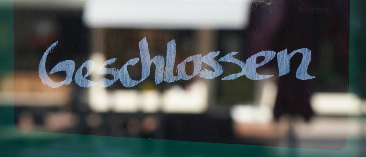 Geschlossen Ein Geschlossen-Schild hinter einer Glasscheibe.