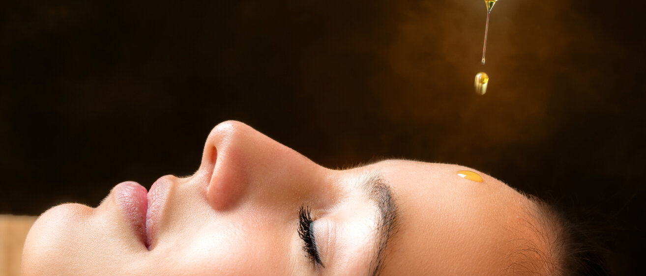 Öl tropft auf Stirn von Frau. © karelnoppe / iStock / Getty Images