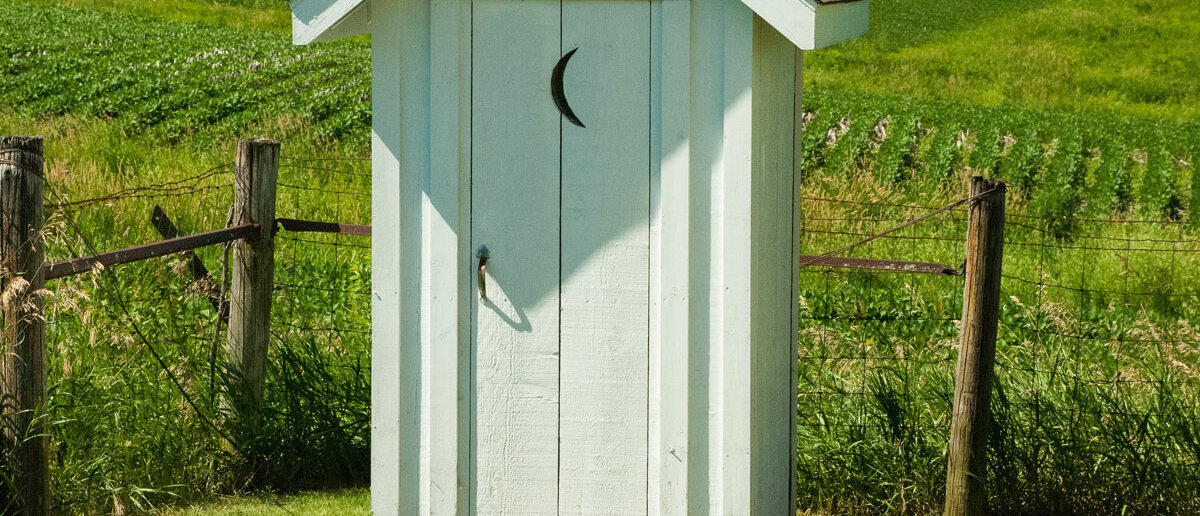 einsames, blaues Toilettenhäuschen