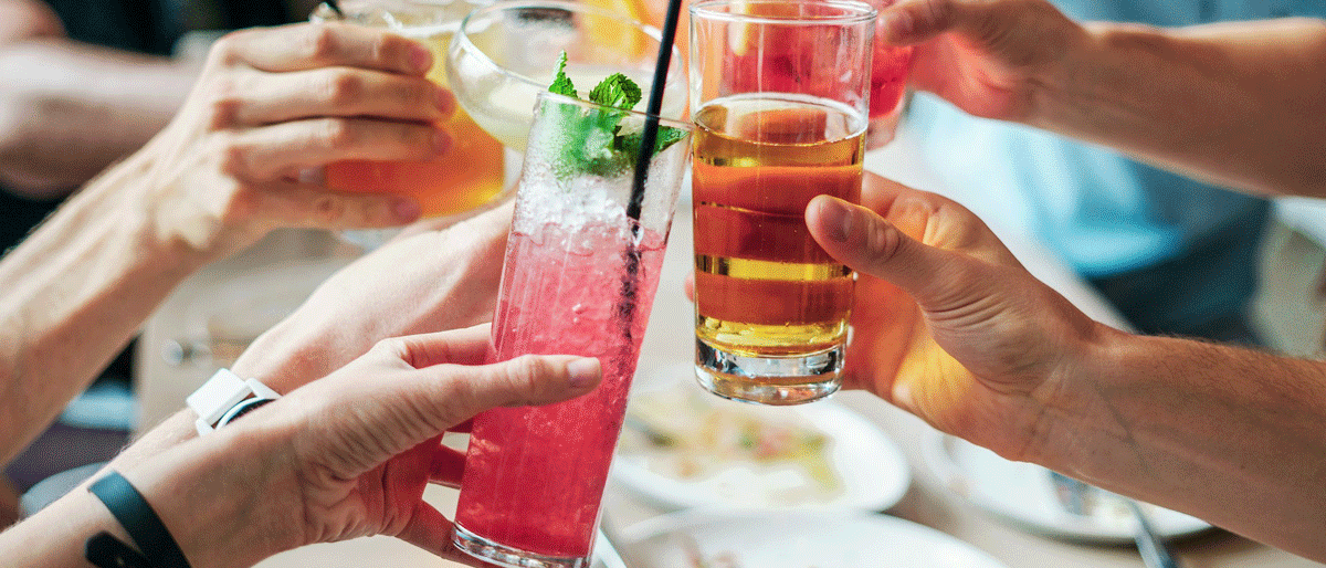 Cocktail-Abend sechs Menschen stoßen mit unterschiedlichen, bunten Cocktails an