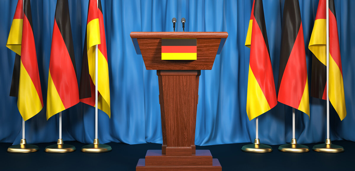 Ein Podium mit Deutschlandflaggen im Hintergrund