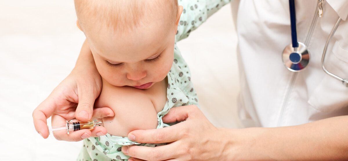 Ein Baby erhält eine Impfung in den Oberarm.