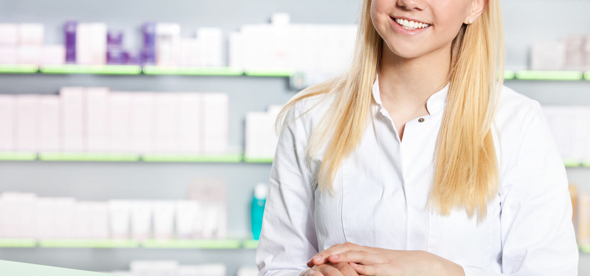 junge PTA im weißen Kittel lächelt im Kamera