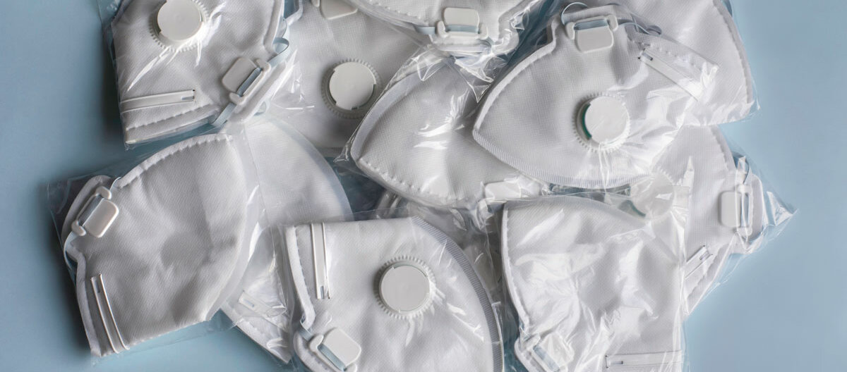 Mehrere FFP2-Masken mit Atemfilter liegen einzeln verpackt beieinander.