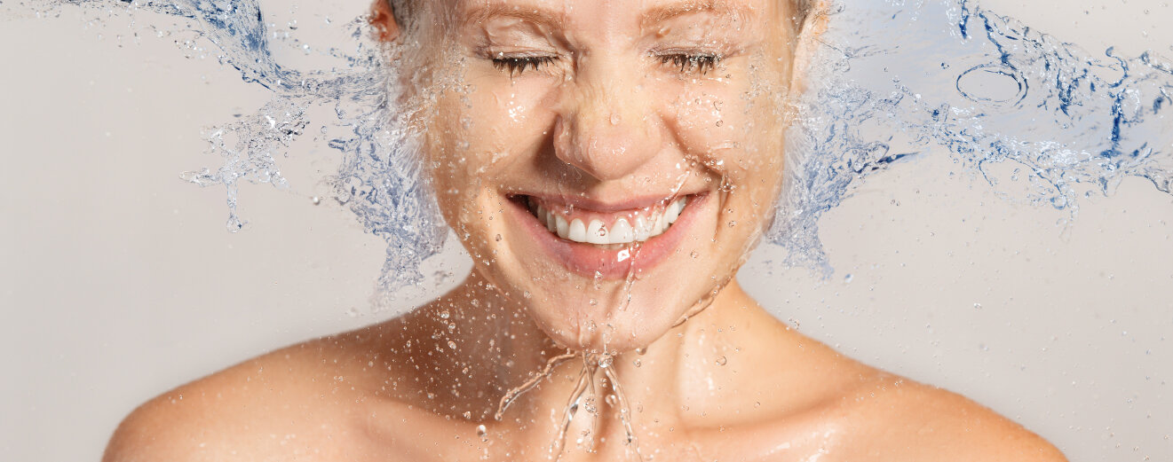 Frau spritzt Wasser ins Gesicht. © evgenyatamanenko / iStock / Getty Images Plus