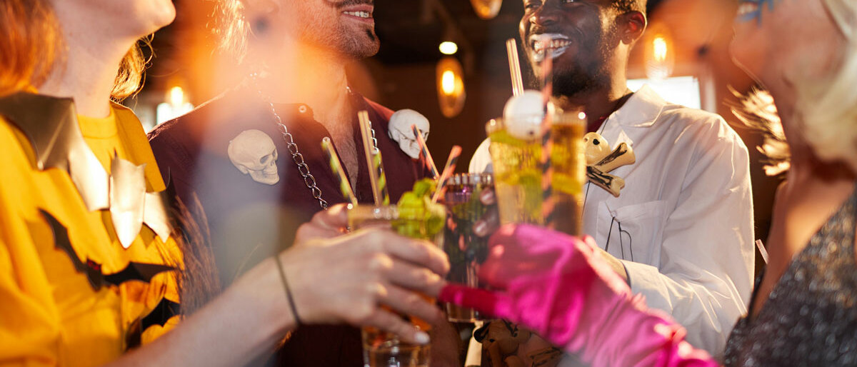 Feiernde, verkleidete Menschen stoßen miteinander an