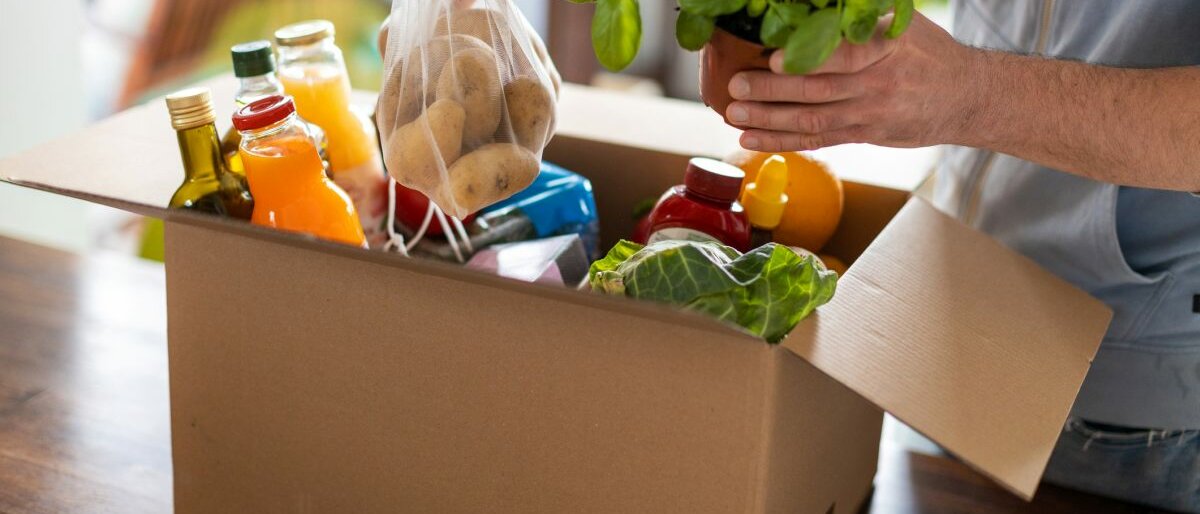 Ein Mann packt ein Paket mit frischen Lebensmitteln aus.