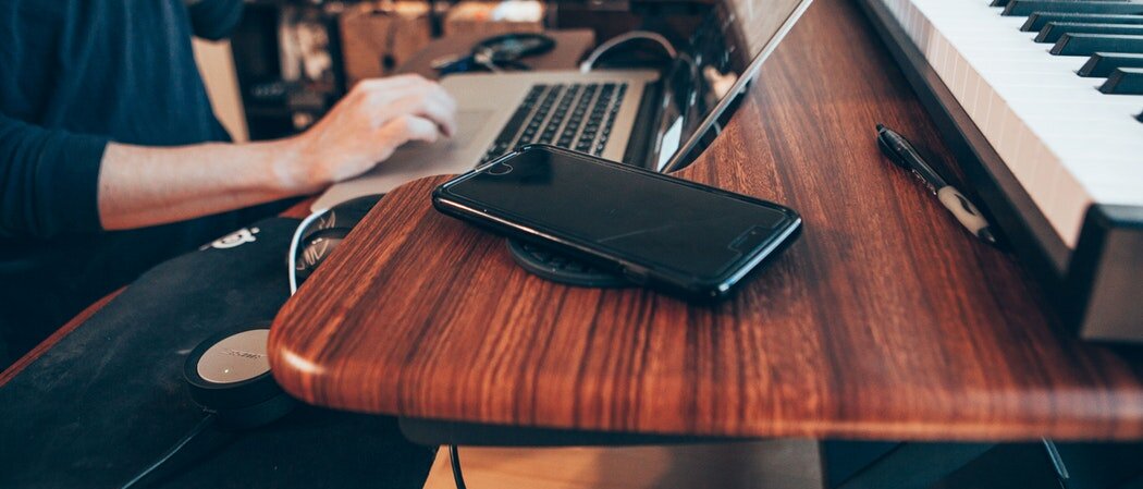 Überforderter Mensch mit Handy am Notebook