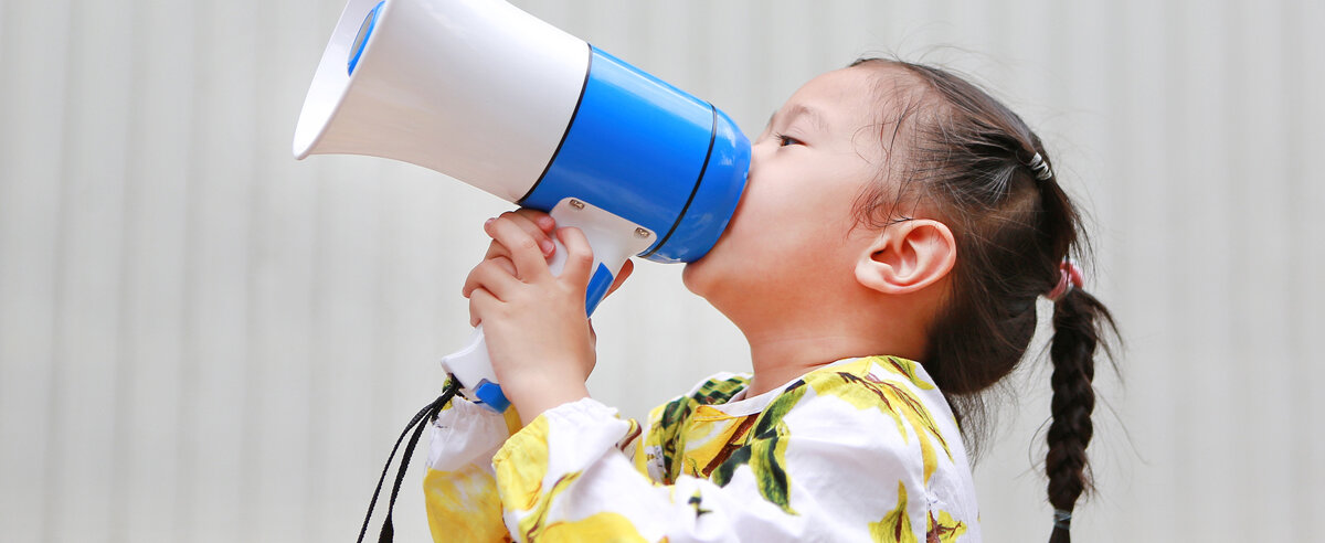 Ein Kind schreit in ein Megaphone