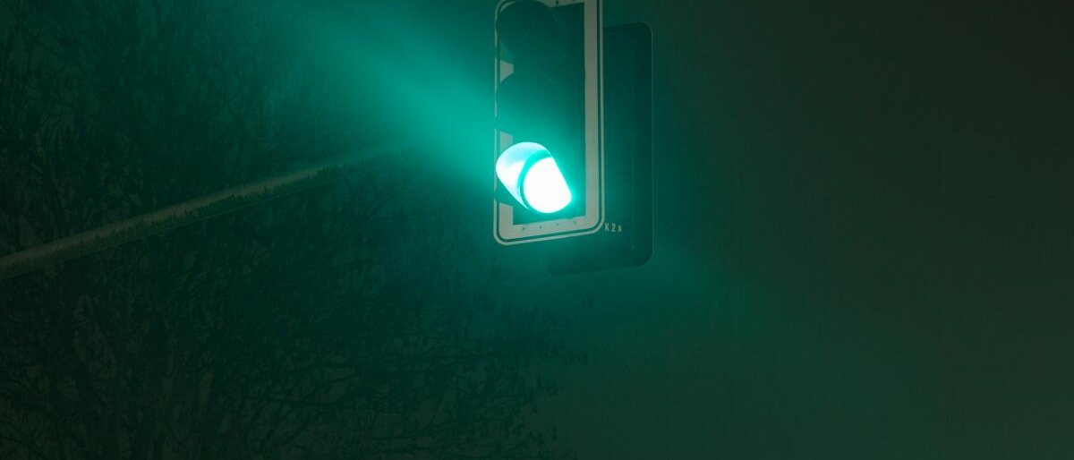 Eine grüne Ampel leuchtet bei Nacht.