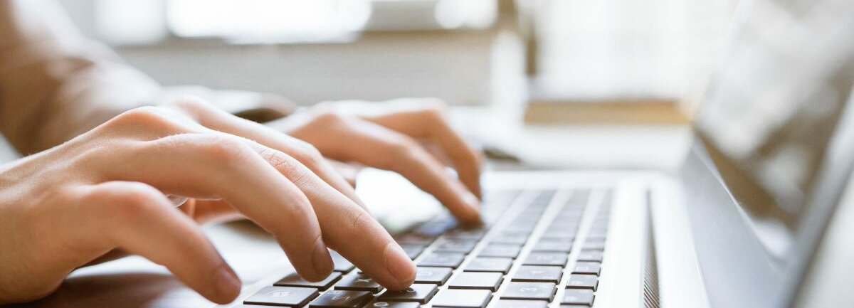 Hände, die auf einem Laptop tippen.