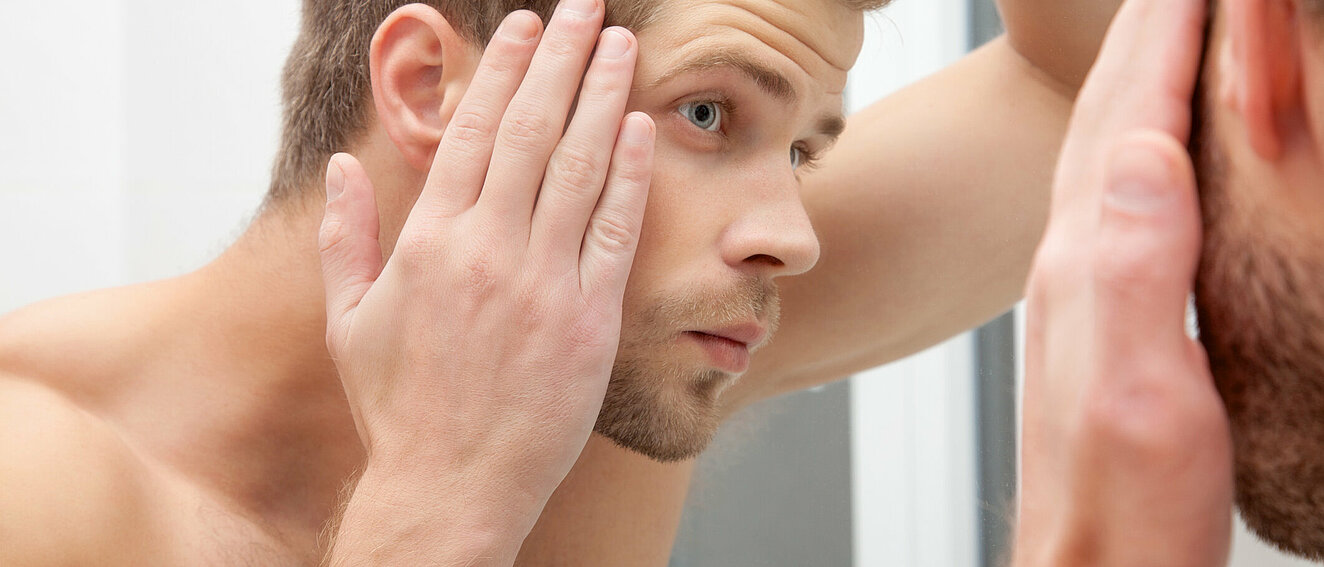Mann prüft seinen Haarwuchs