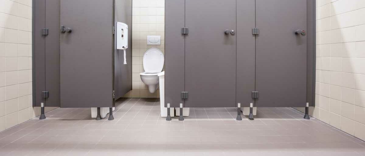 Toilettenkabinen 4 Kabinen einer öffentlichen Damentoilette, eine Kabinentür steht offen.