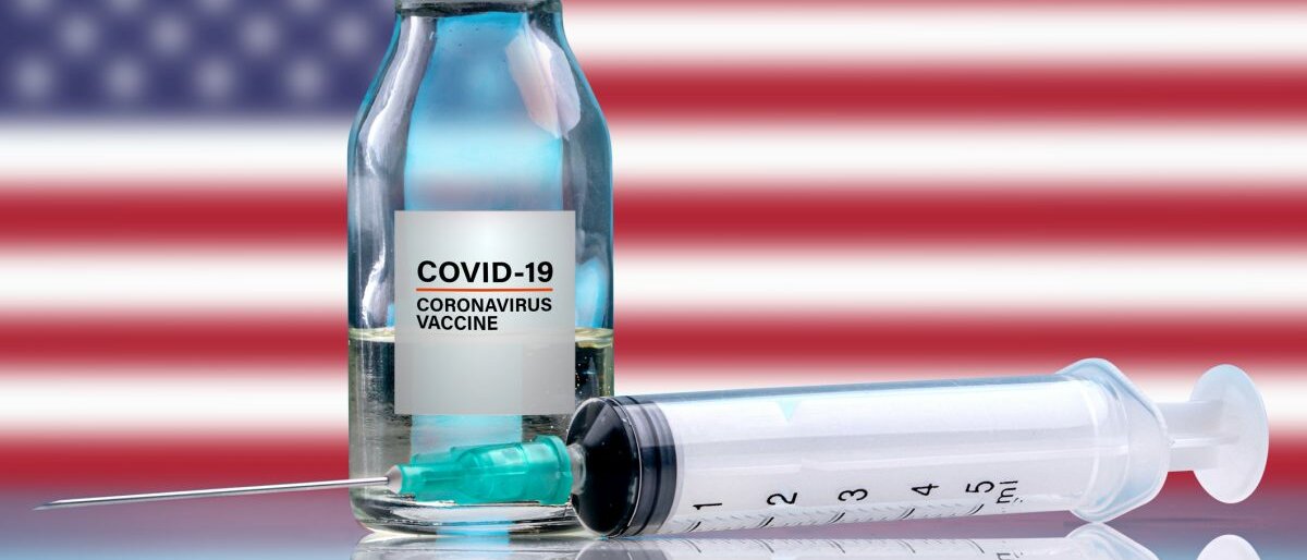 Ein Corona-Impfstoff vor einer US-amerikanischen Flagge.
