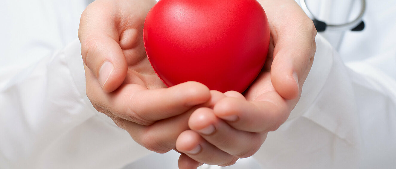 Jemand hält ein rotes Herz in der Hand