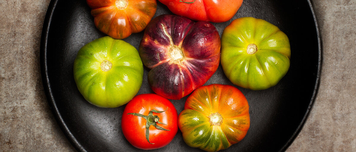 Verschiedene Tomatensorten liegen in einer Pfanne.