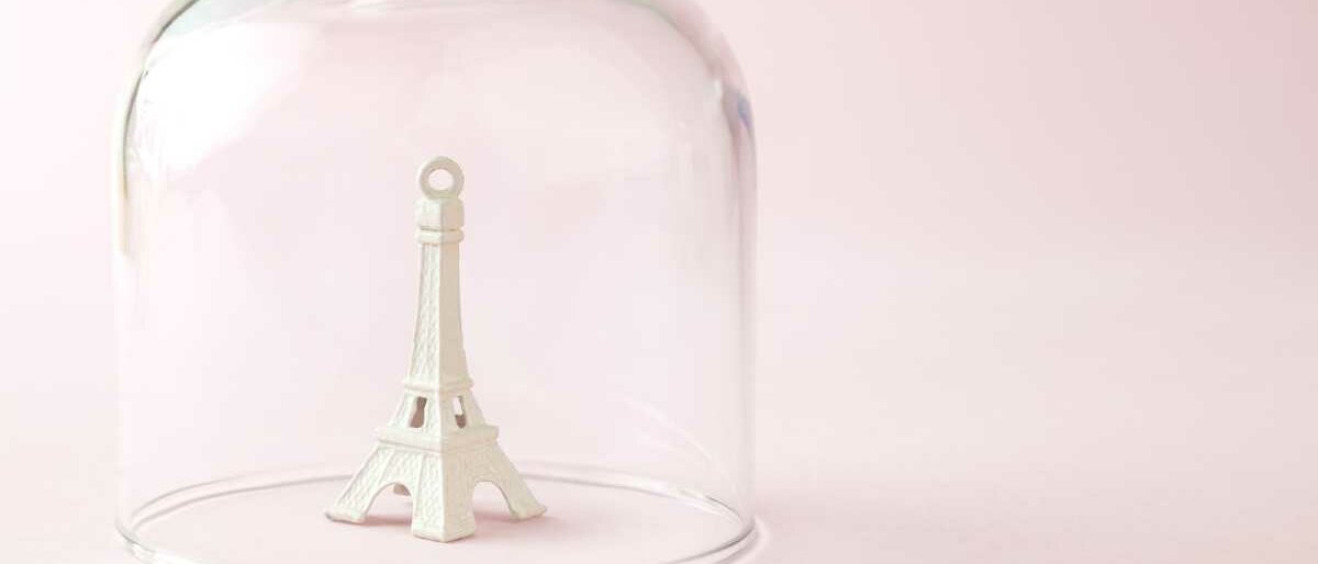 Eine Figur des Eiffelturms wird durch eine Glasglocke abgedeckt.