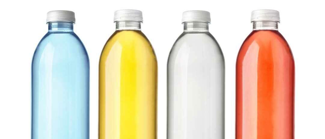 Vier unbeschriftete Kunststoffflaschen enthalten verschiedenfarbige Lösungen.