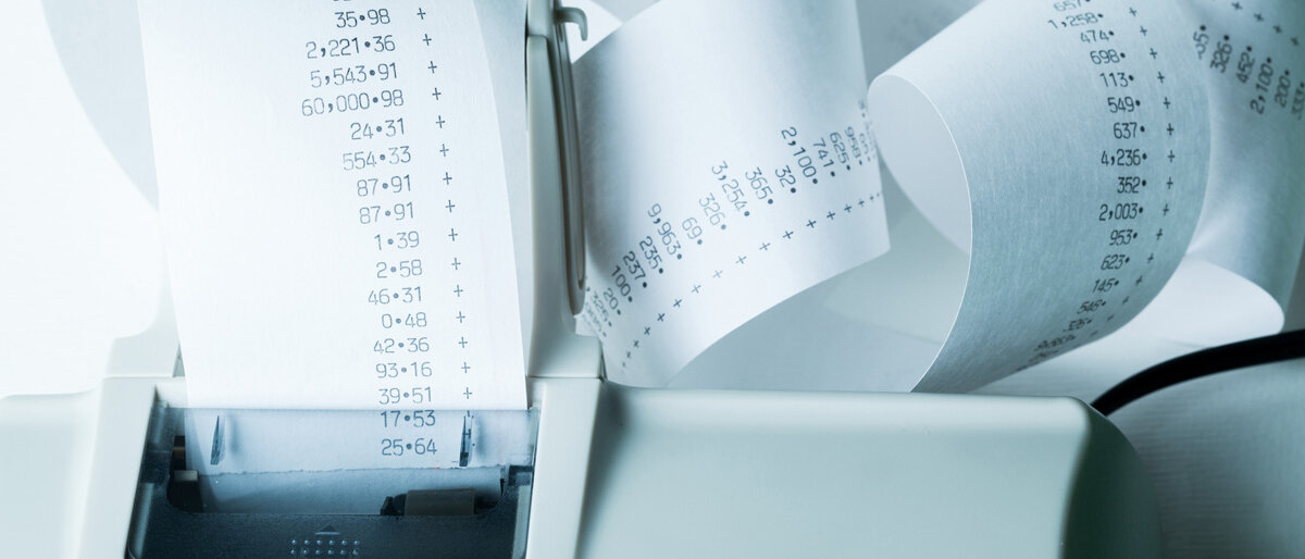 Ein Drucker spuckt einen mehrfach gerollten, langen Bon aus