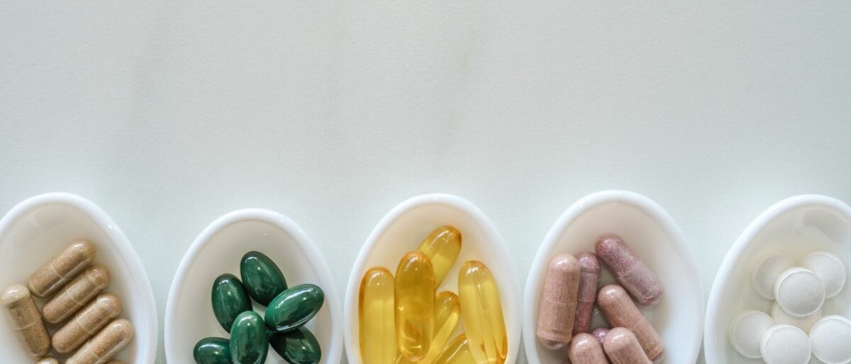 Verschiedene Nahrungsergänzungsmittel auf weißen Löffeln.