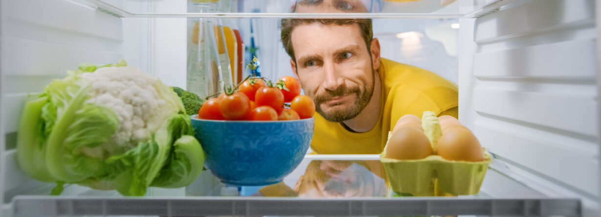 Mann schaut in den Kühlschrank. © gorodenkoff / iStock / Getty Images Plus