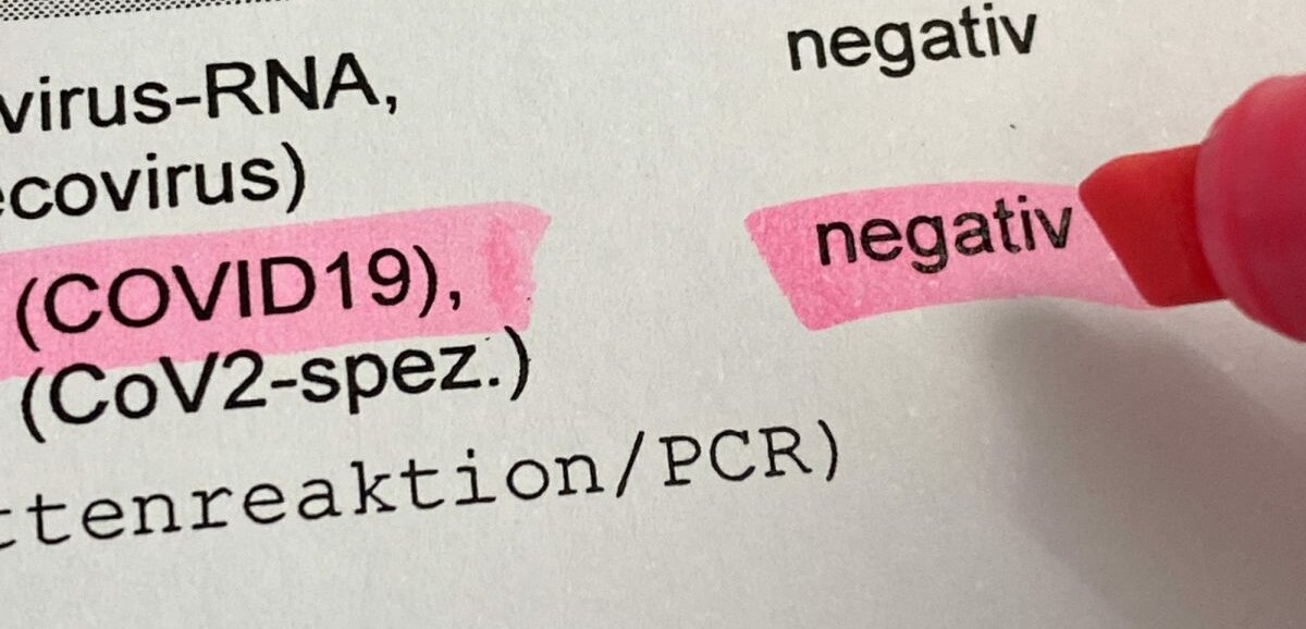 Papier Ein Blatt Papier auf dem ein negatives COVID-19-Testergebnis dokumentiert ist.