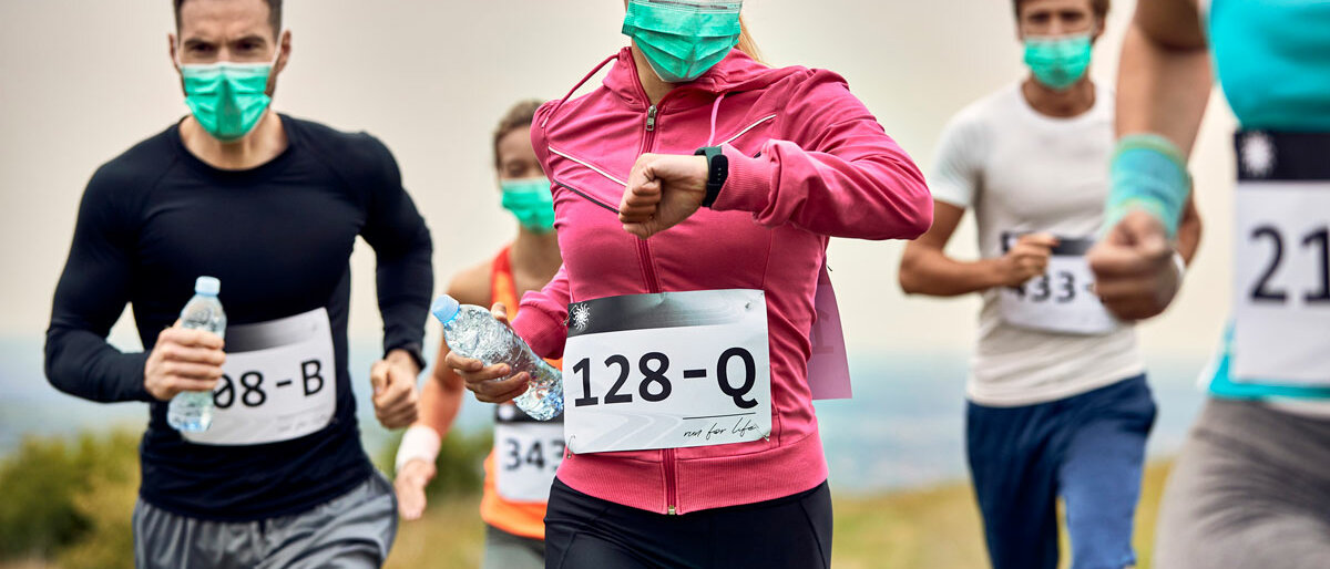 Mehrere Marathonläufer*innen tragen Mund-Nasen-Masken.