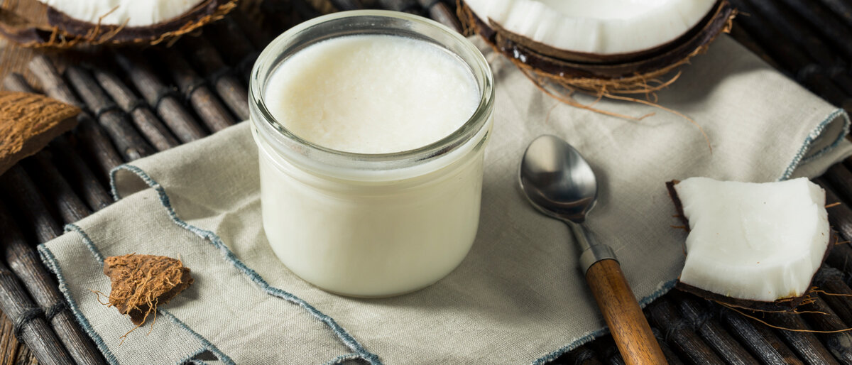 Kokosnusshälften und eine Schale Kokosöl auf einem Tisch