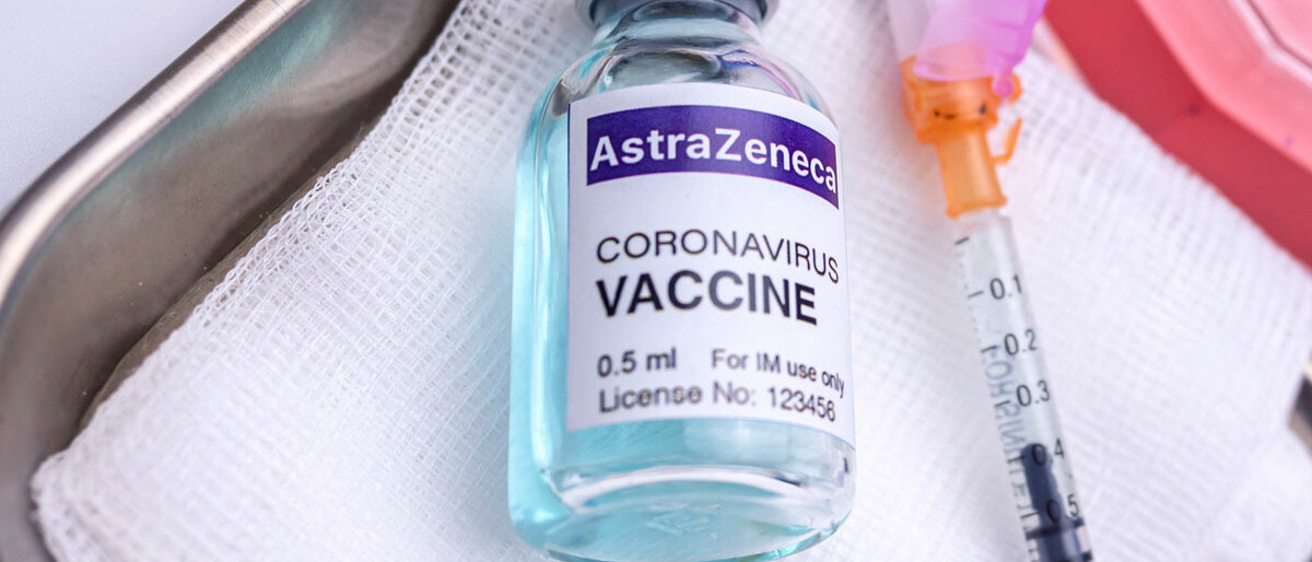 Ein Mehrdosenbehältnis mit dem Impfstoff von AstraZeneca und ein Impfbesteck liegen in einer Metallschale.
