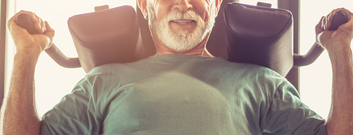 Älterer Mann trainiert seinen Rücken an einem Fitnessgerät