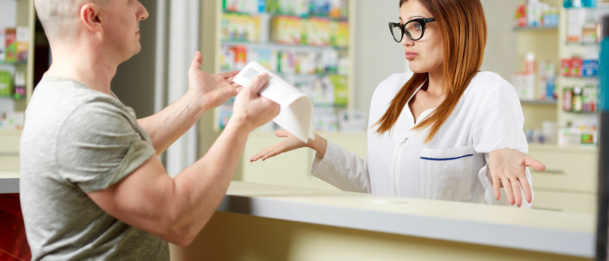Ein verärgerter Kunde vor einer ratlosen Apothekenangestellten