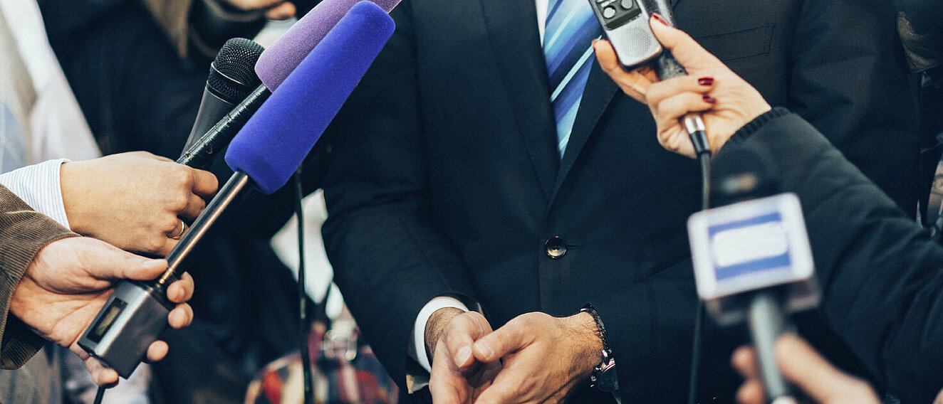 Reporter mit Mikrofonen © microgen / iStock / Getty Images