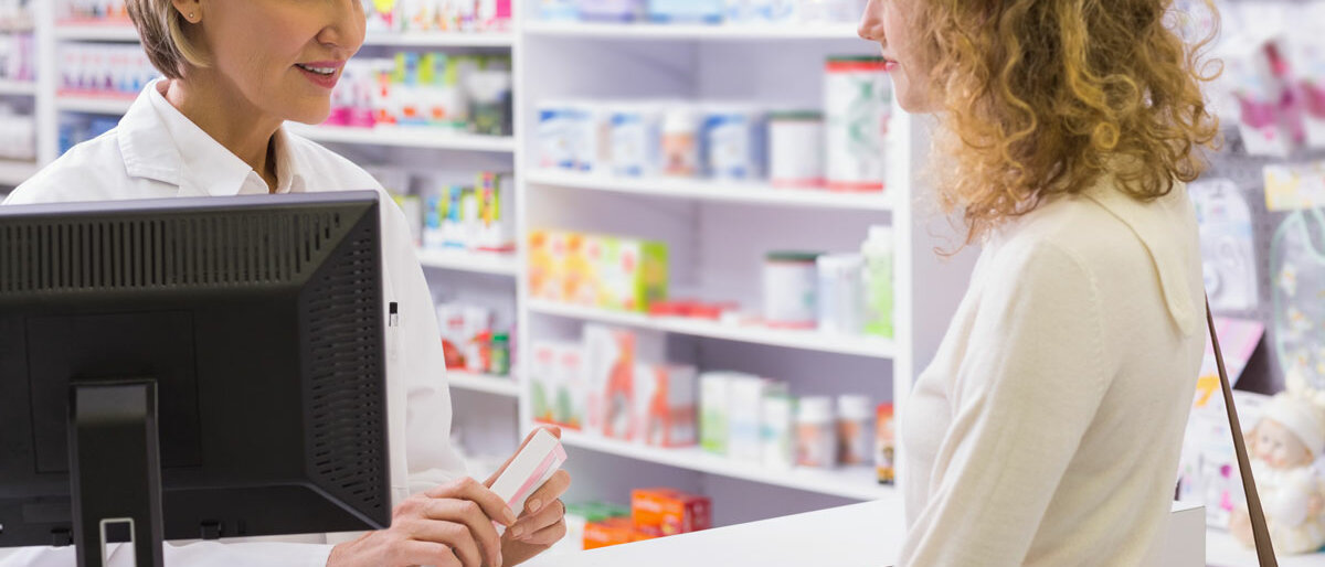 Eine Frau in der Apotheke wird von Apothekerin bedient