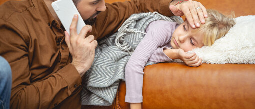Mann fühlt Temperatur bei Kind. © yacobchuk / iStock / Getty Images